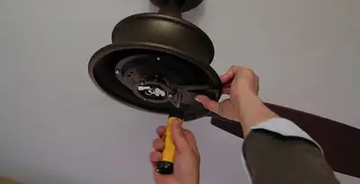Electrician installing ceiling fan mounting bracket and fixture in Bakersfield, CA