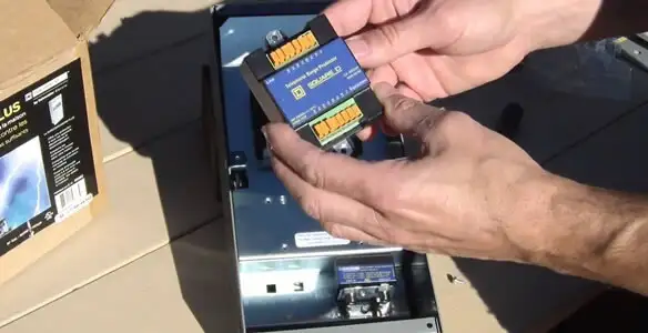 Electrician installing whole home surge protection unit inside main electrical panel in Bakersfield, CA