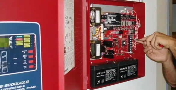 fire alarm installation service showing technician configuring fire alarm control panel in Bakersfield, CA