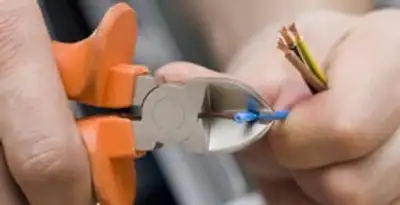 professional electrical services showing precise wire cutting by licensed electricians in Bakersfield, CA