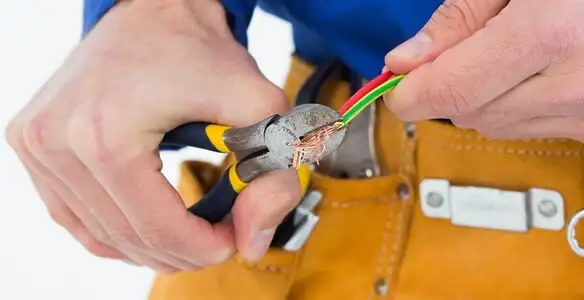 licensed electrician securing electrical wiring with professional tools during service work in Bakersfield, CA