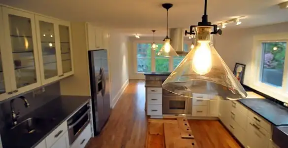 Residential electrician installing modern indoor light fixture in a home in Bakersfield, CA