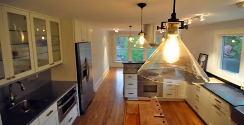 Residential electrician installing modern indoor light fixture in a home in Bakersfield, CA